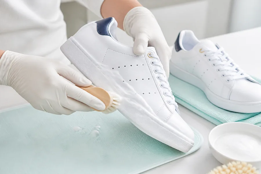Professional cleaning of a white sneaker with a detailing brush